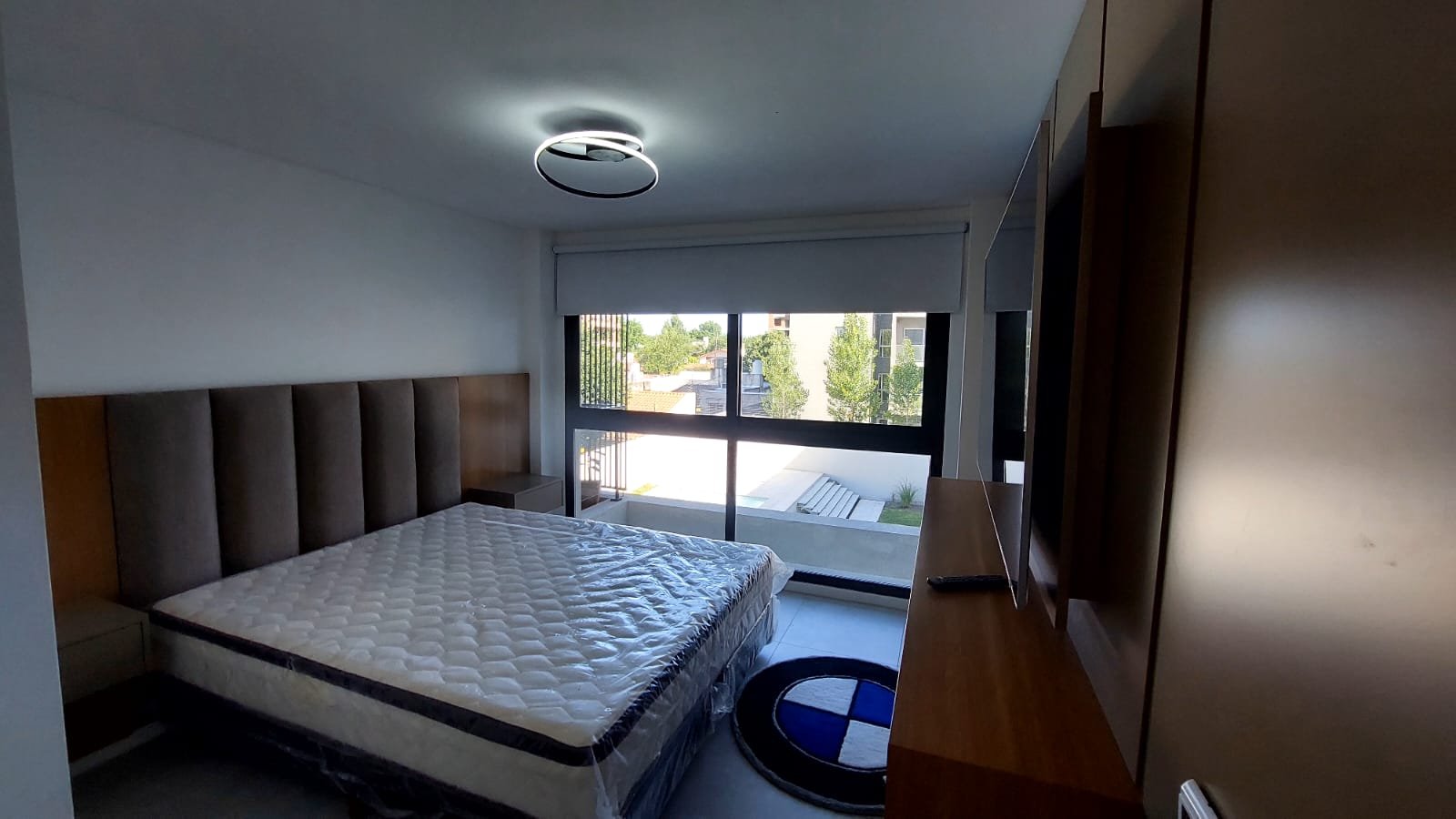 Dormitorio moderno con luz cálida y detalles grises y madera — proyecto Obra el Visón, por Licefe Carpentry SRL, en Ituzaingó